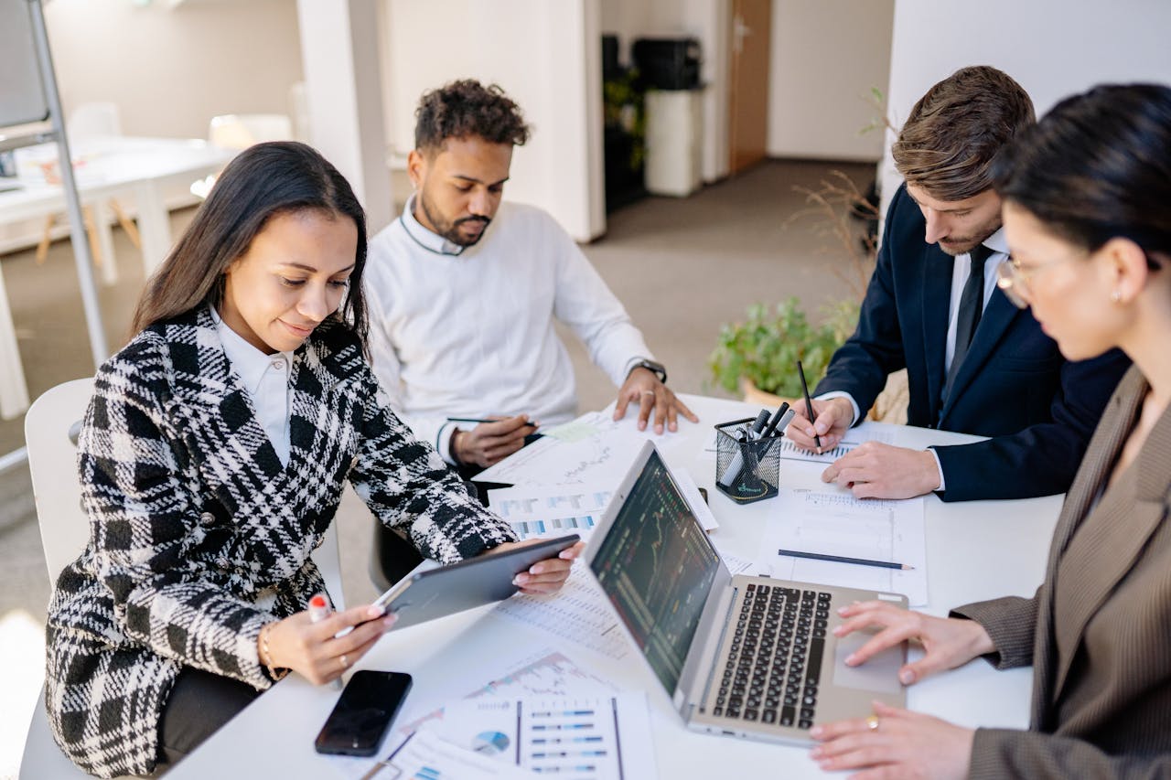 Business team engaged in planning and analysis with laptops and papers at a modern office.